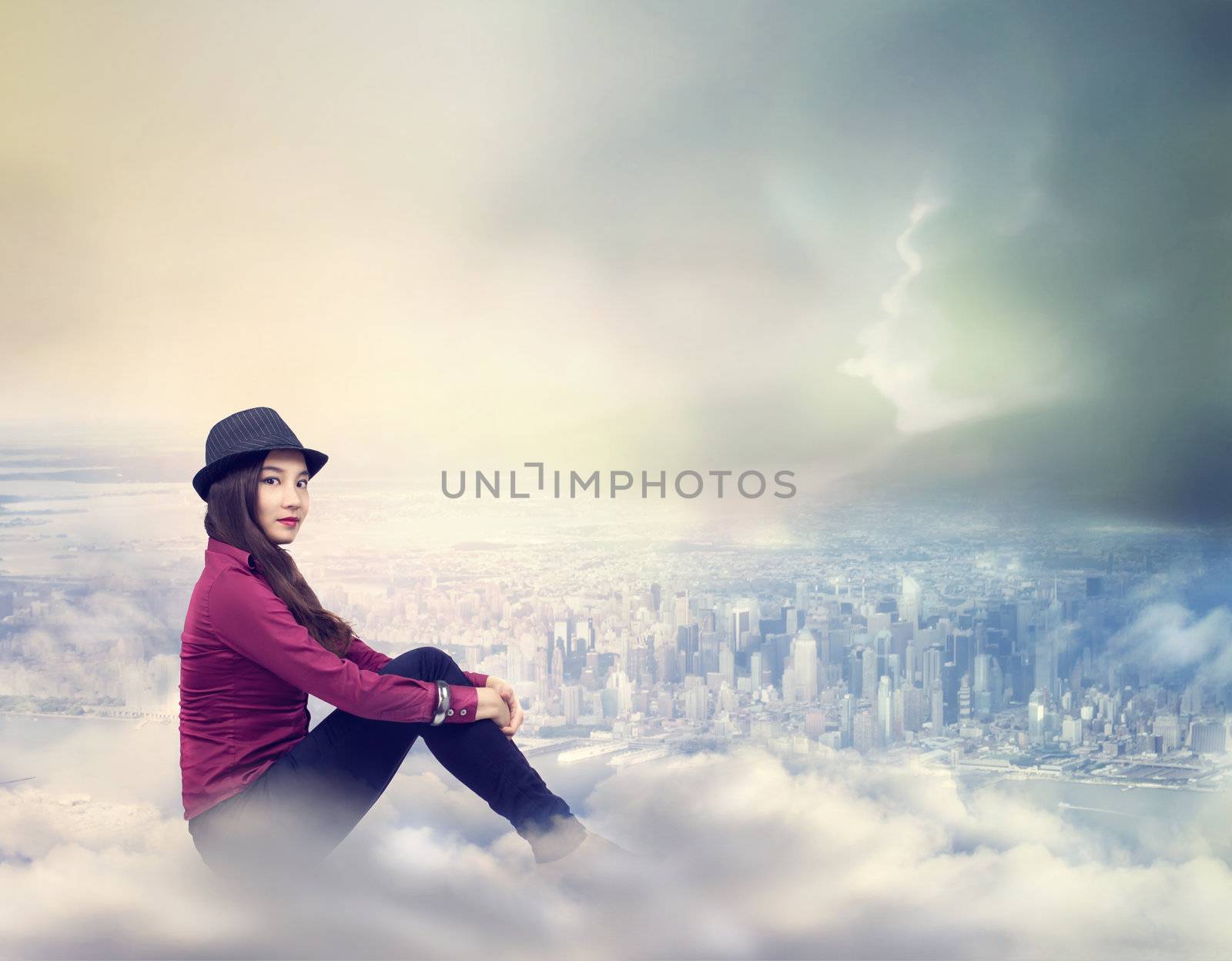 Happy Young Woman Sitting on the Clouds Above the City