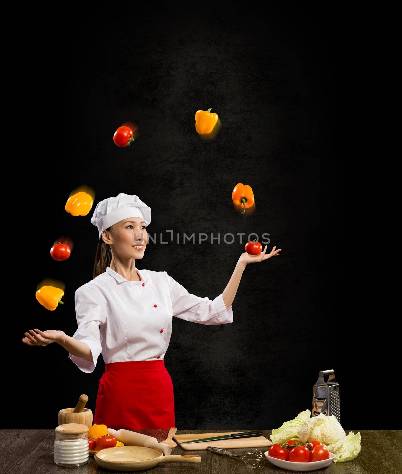 Asian woman chef juggling with vegetables, cooking skills
