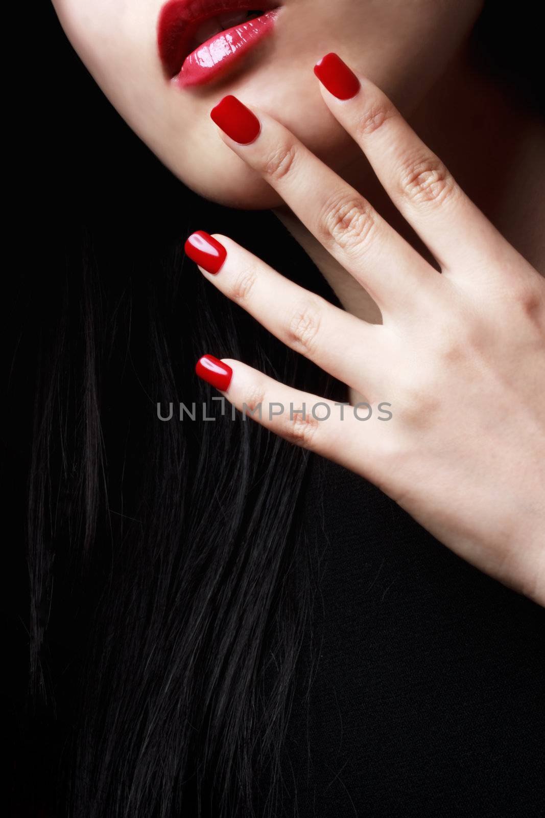 Close up of womans red nails, lips and long black hair