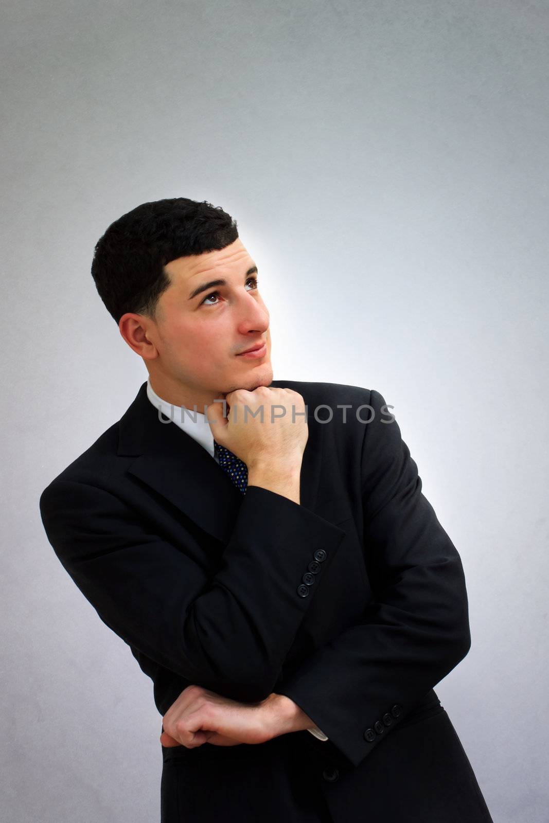 Young business man thinking in black suit  by melpomene