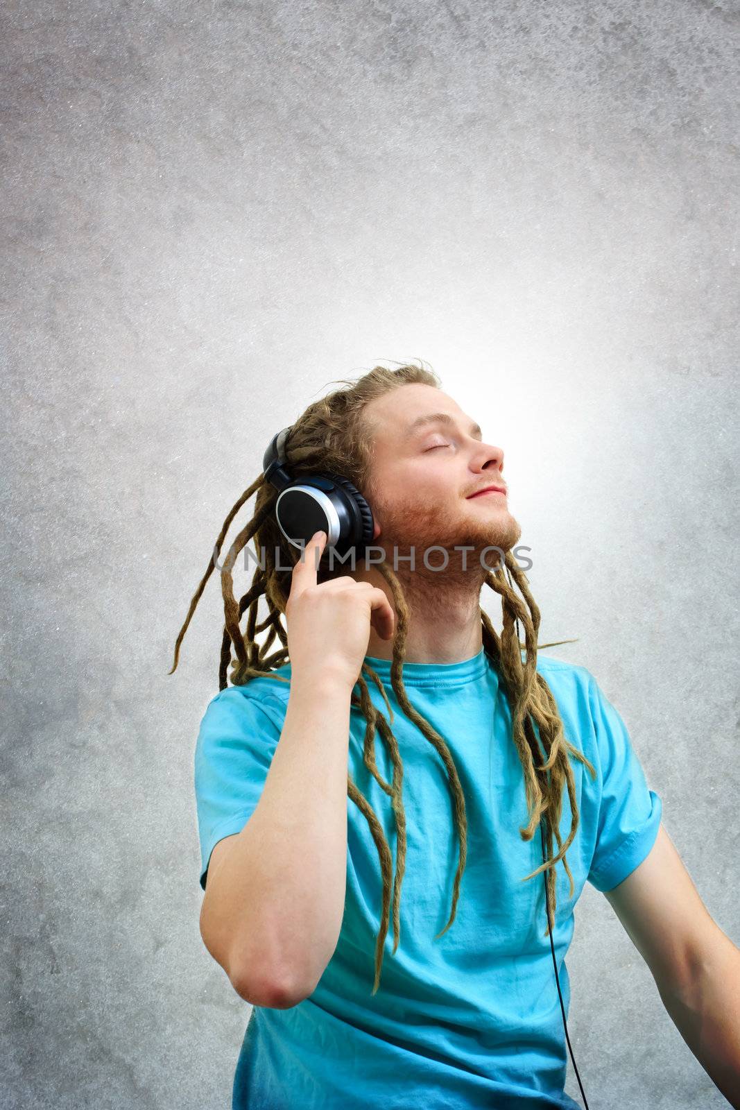 Portrait of a Young Man with Dreadlocks Listening to Music on Headphones  by melpomene