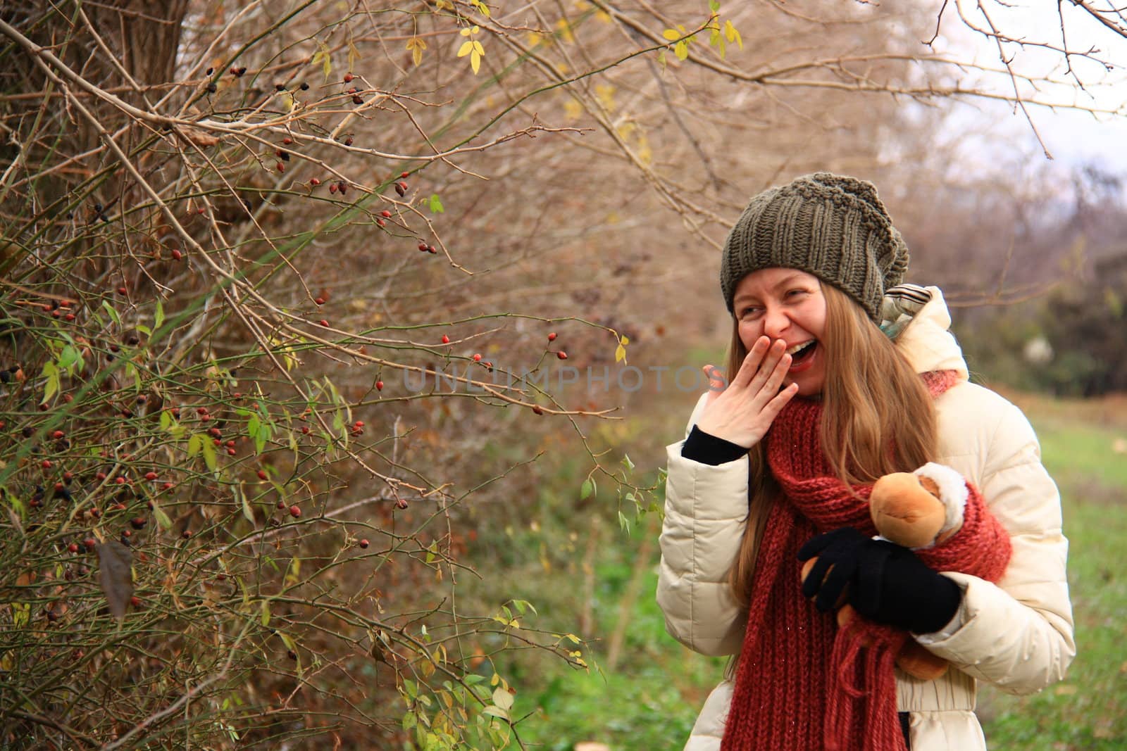 girl playing with doll in forest while smiling 