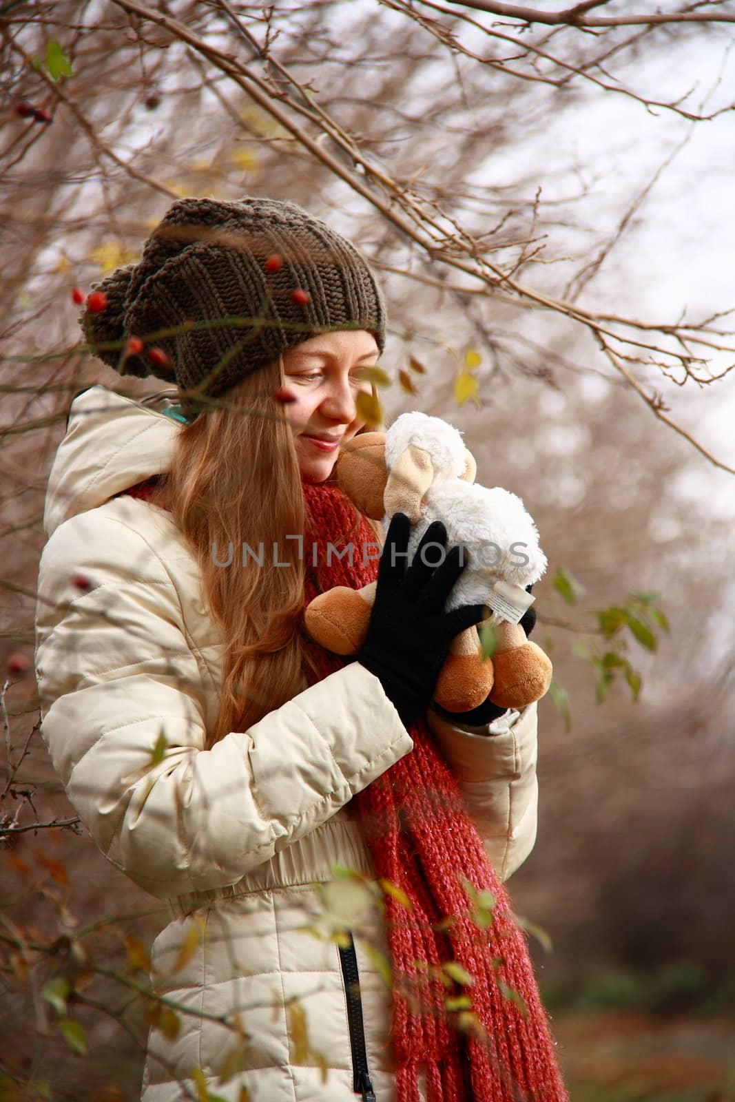 girl playing with doll in forest while smiling 