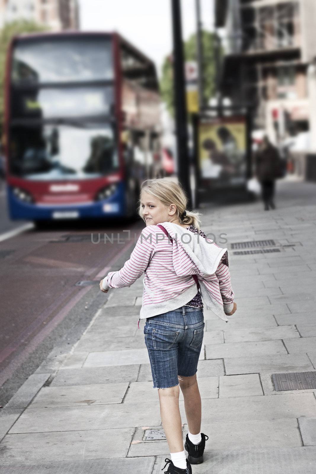 A girl on a street in a city. Grunge feel, short depth of field. Film grain applied
