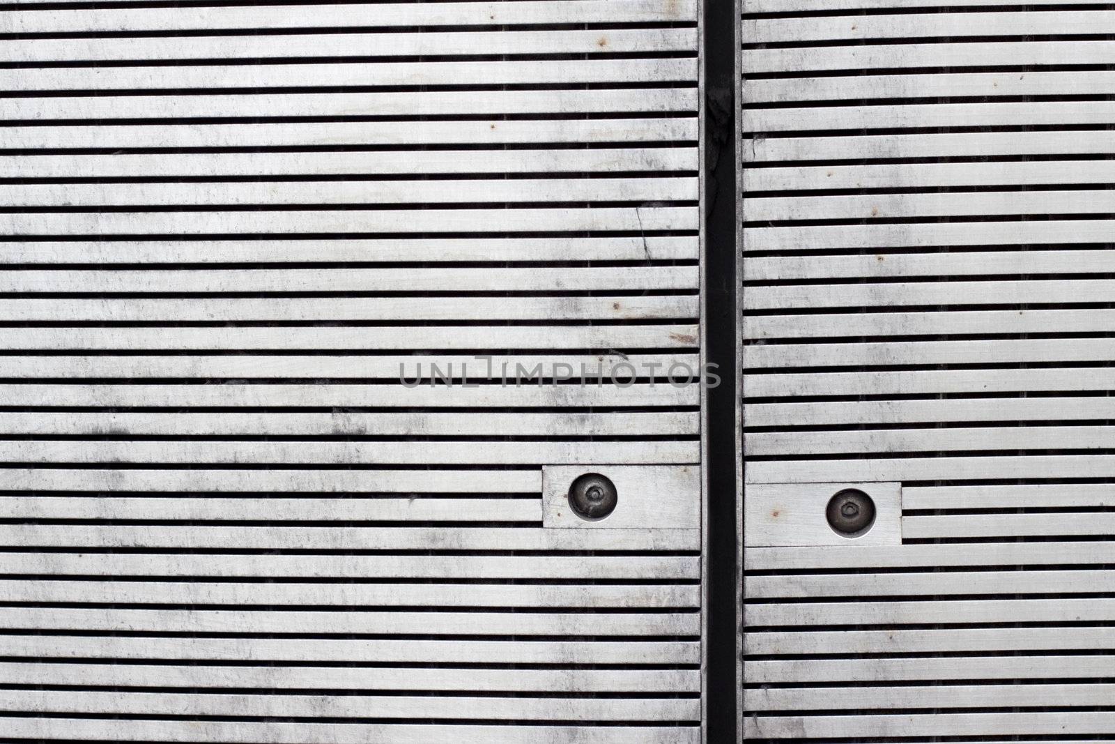 Close up of panels with horizontal slats cladding a facade with rusty screws
