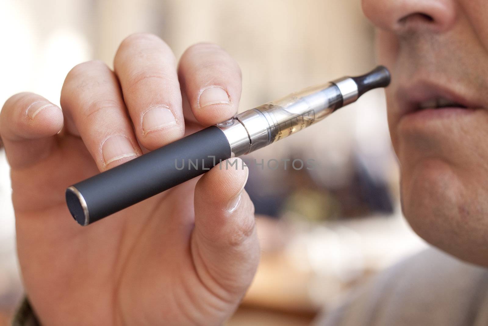 Close up of a man inhaling from an electronic cigarette