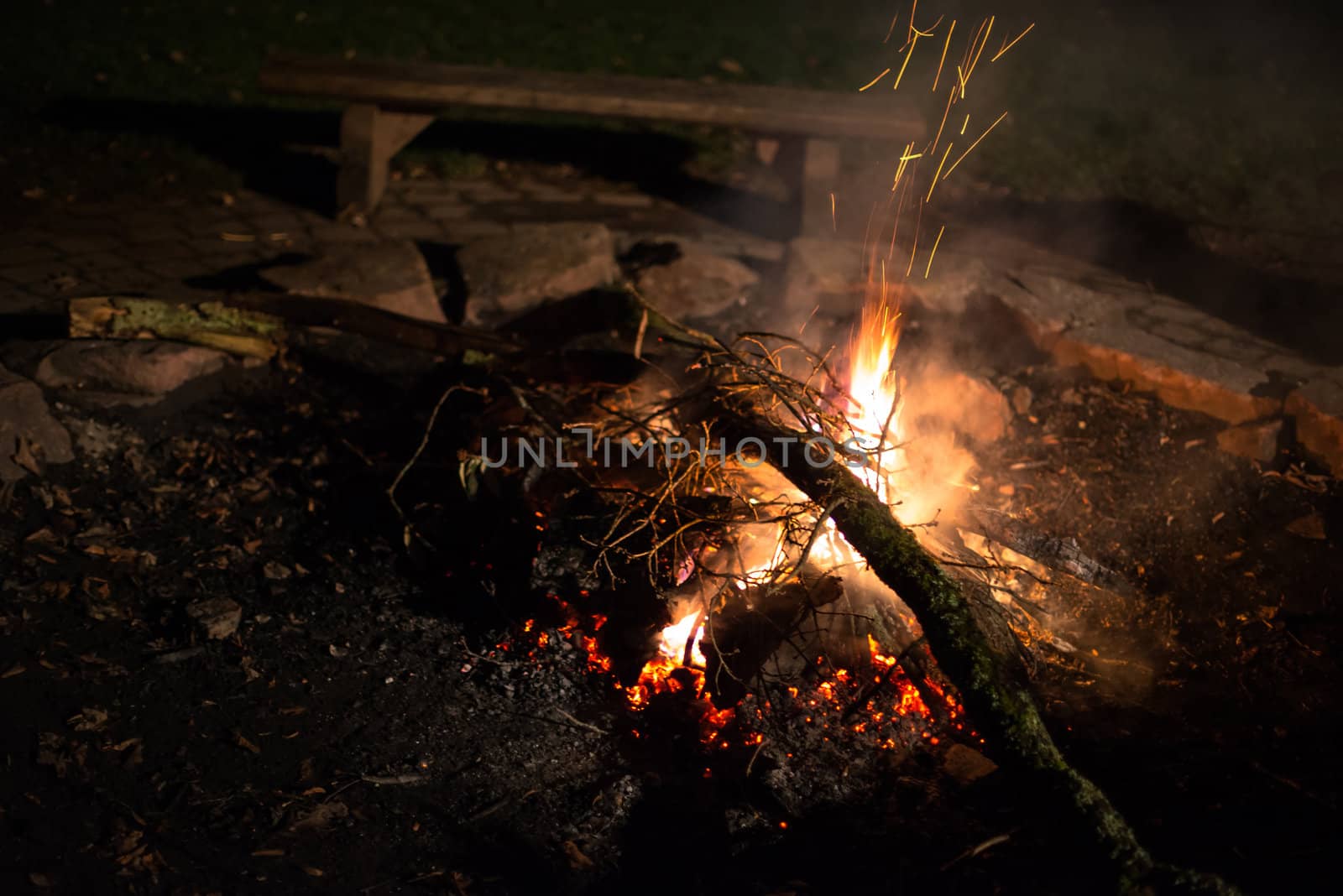 Flames of a cozy campfire flicker in a light breeze