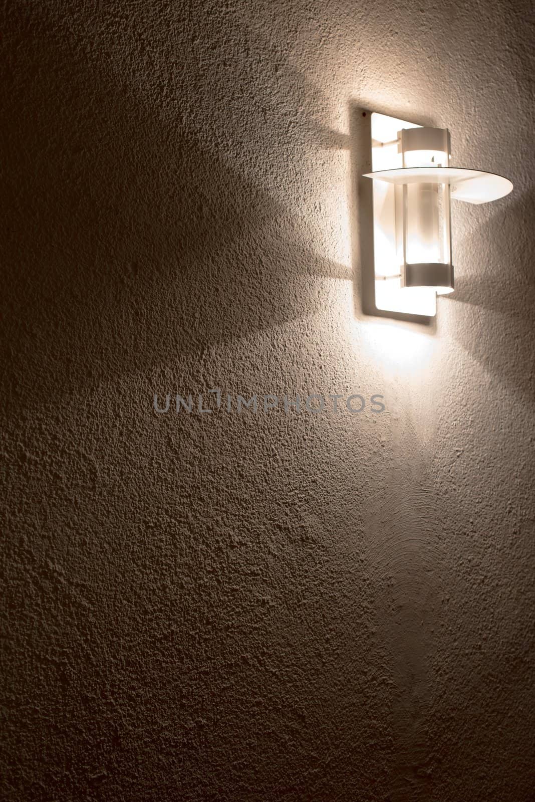 Modern lamp on concrete wall with great shadows