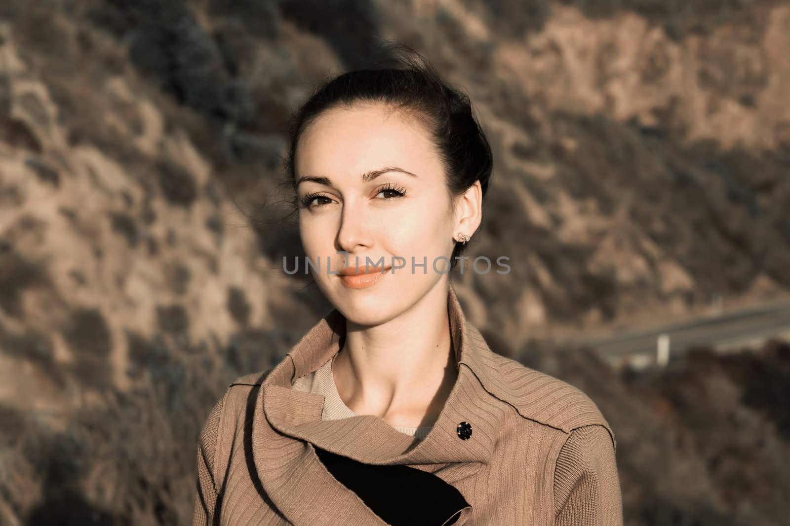 Portrait of a beautiful brunette on a background of mountain road