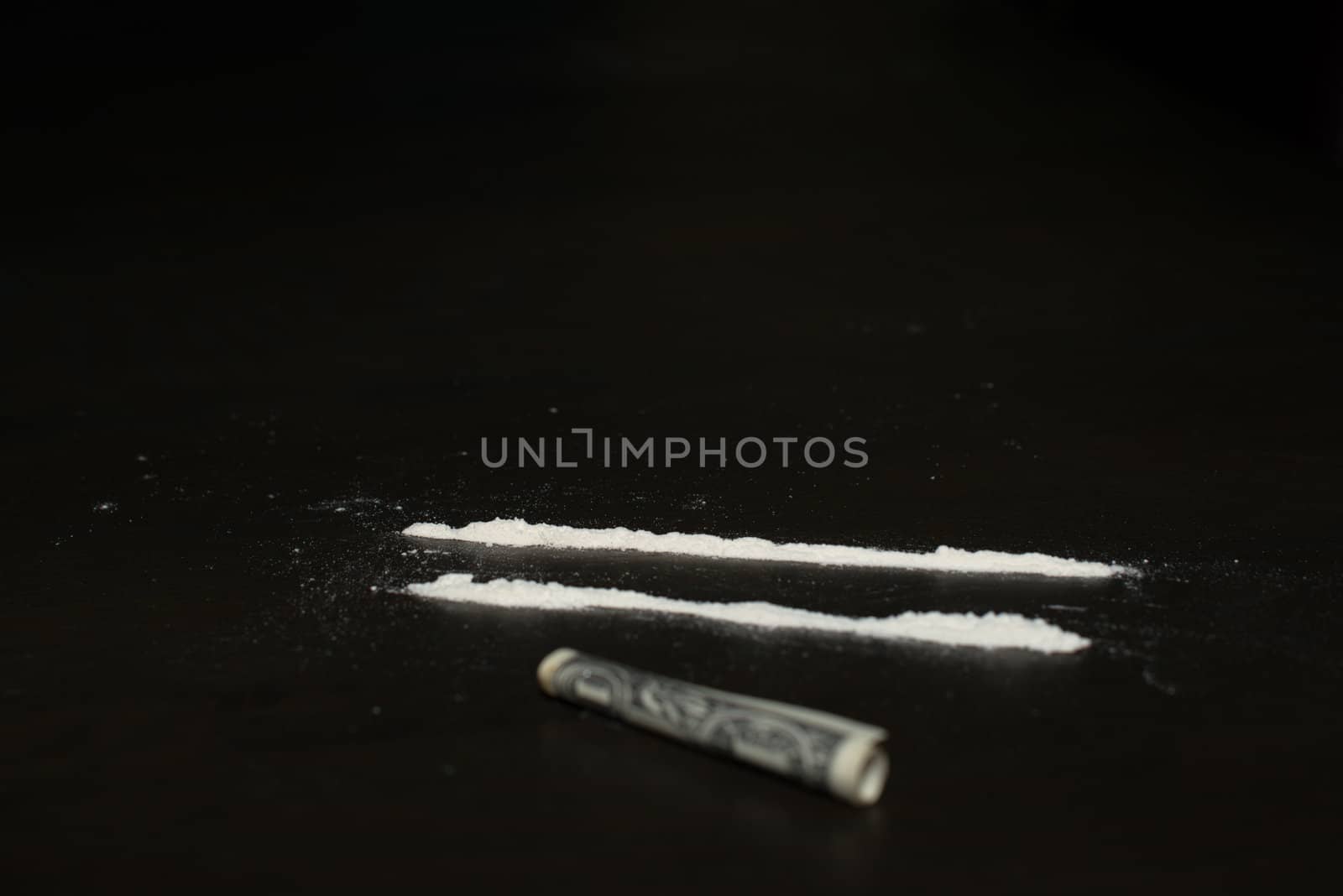 Drug abuse: Two rows of cocaine being prepared for sniffing with a dollar bill lying in the front