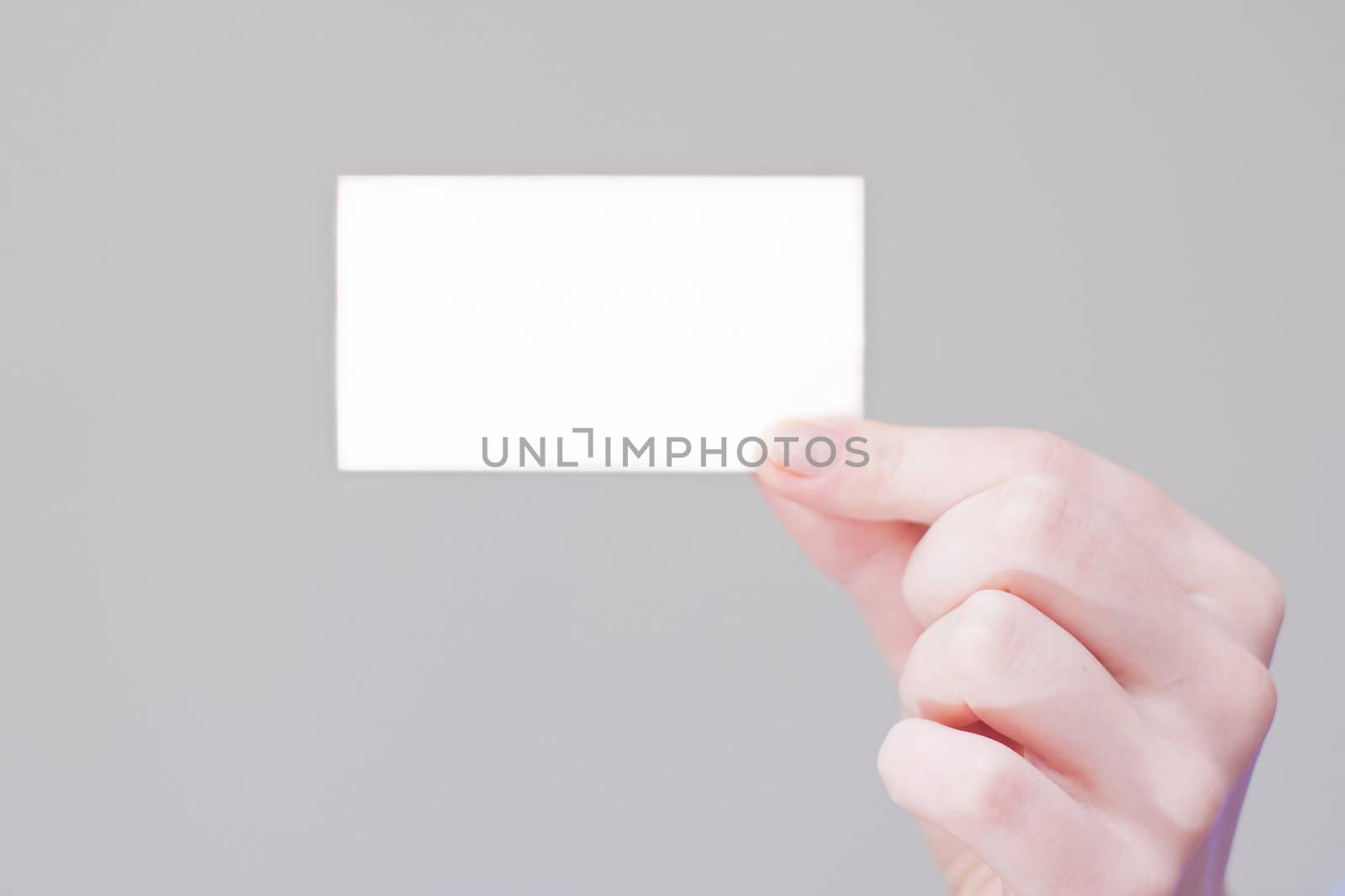 bussines card in hand for your information and logo in a grey background