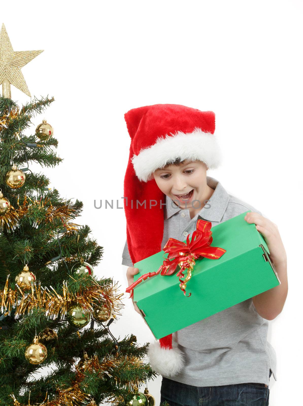 surprised boy in santa hat with christmas present on white background