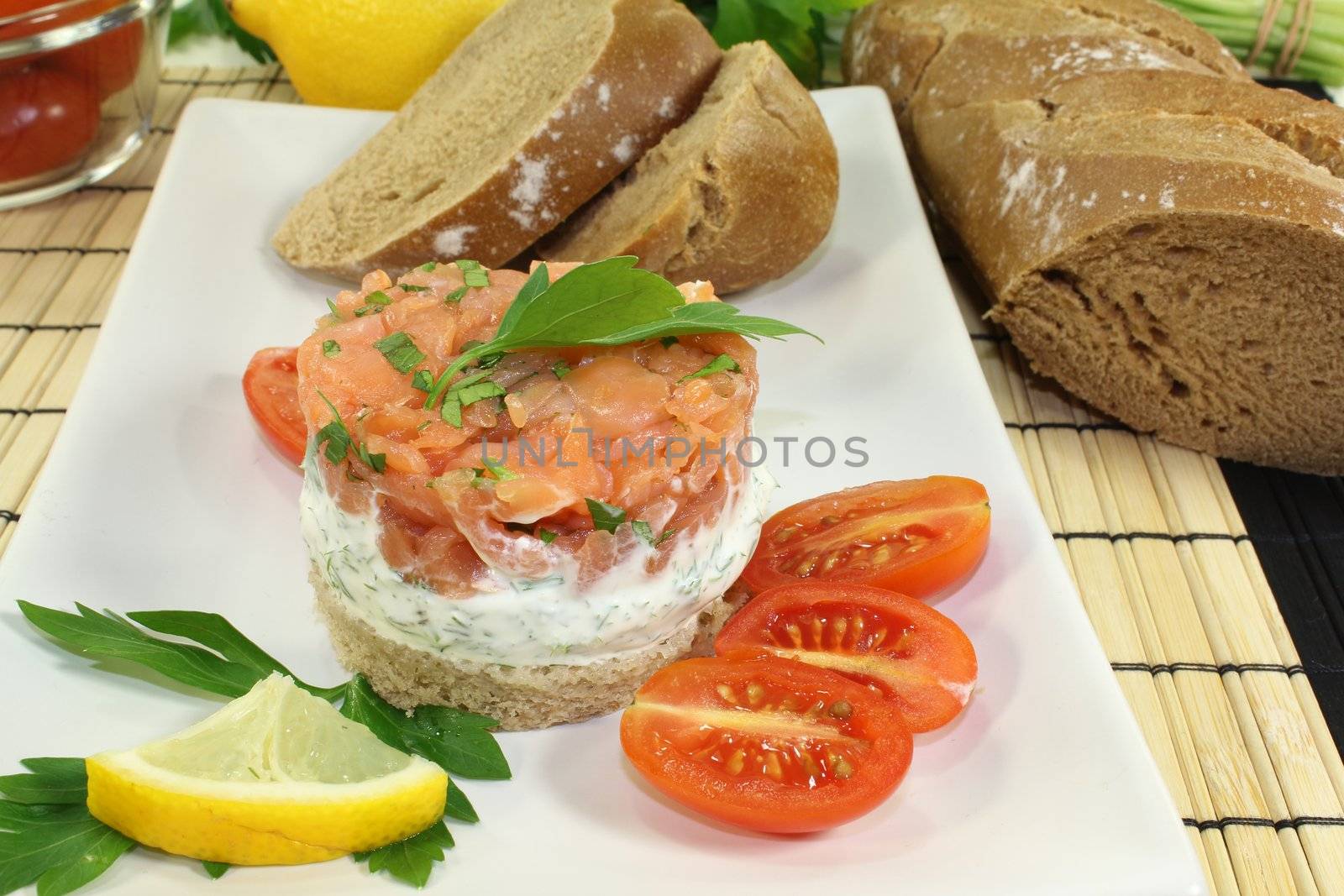 freshly prepared salmon tartare with creme fraiche, bread and parsley