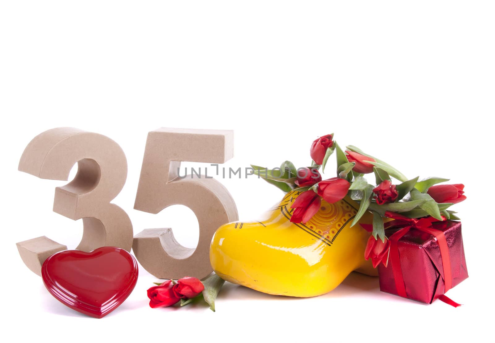 Number of age in a colorful studio setting and Dutch looking attributes like a clog woonden shoe and tulips