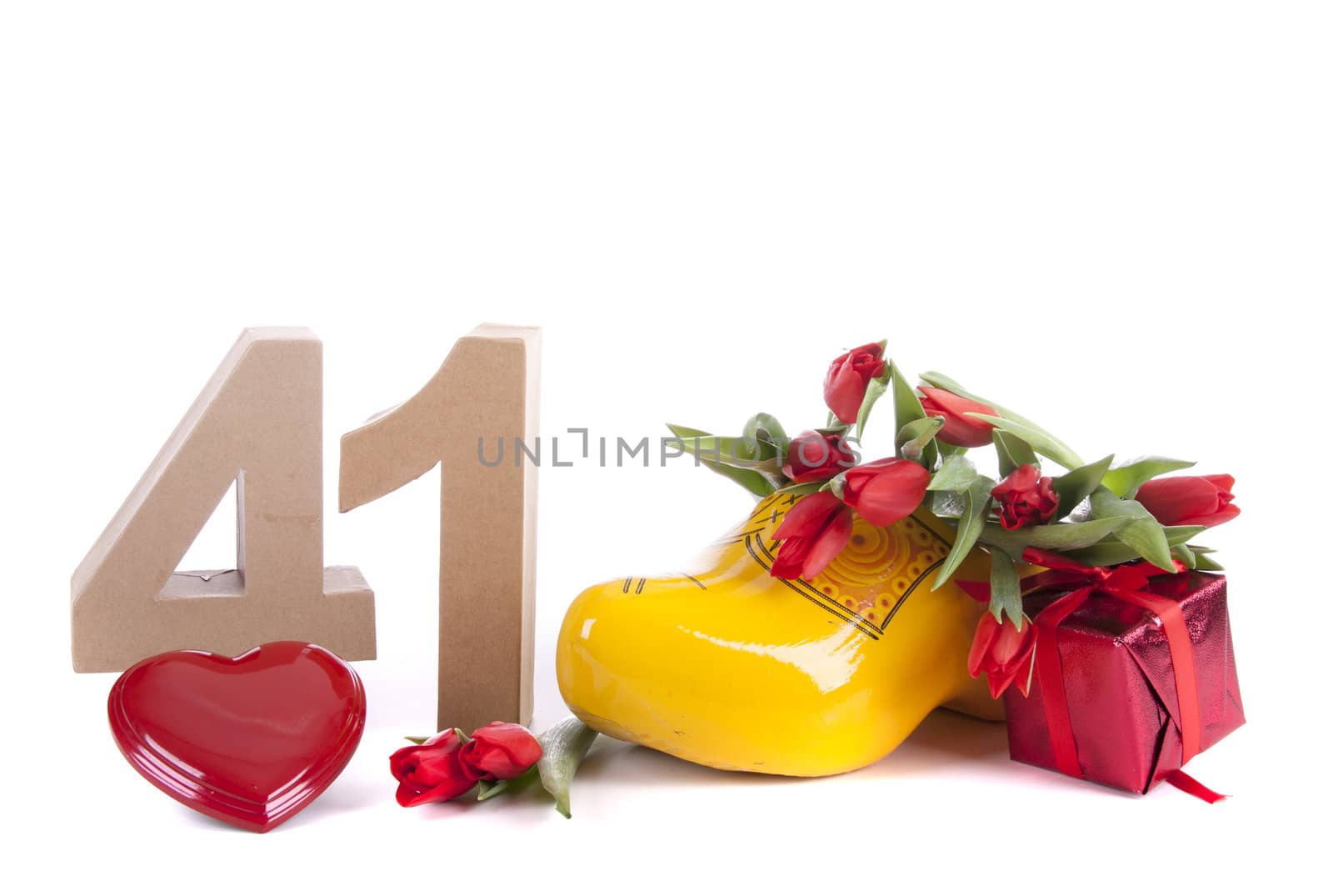 Number of age in a colorful studio setting and Dutch looking attributes like a clog woonden shoe and tulips