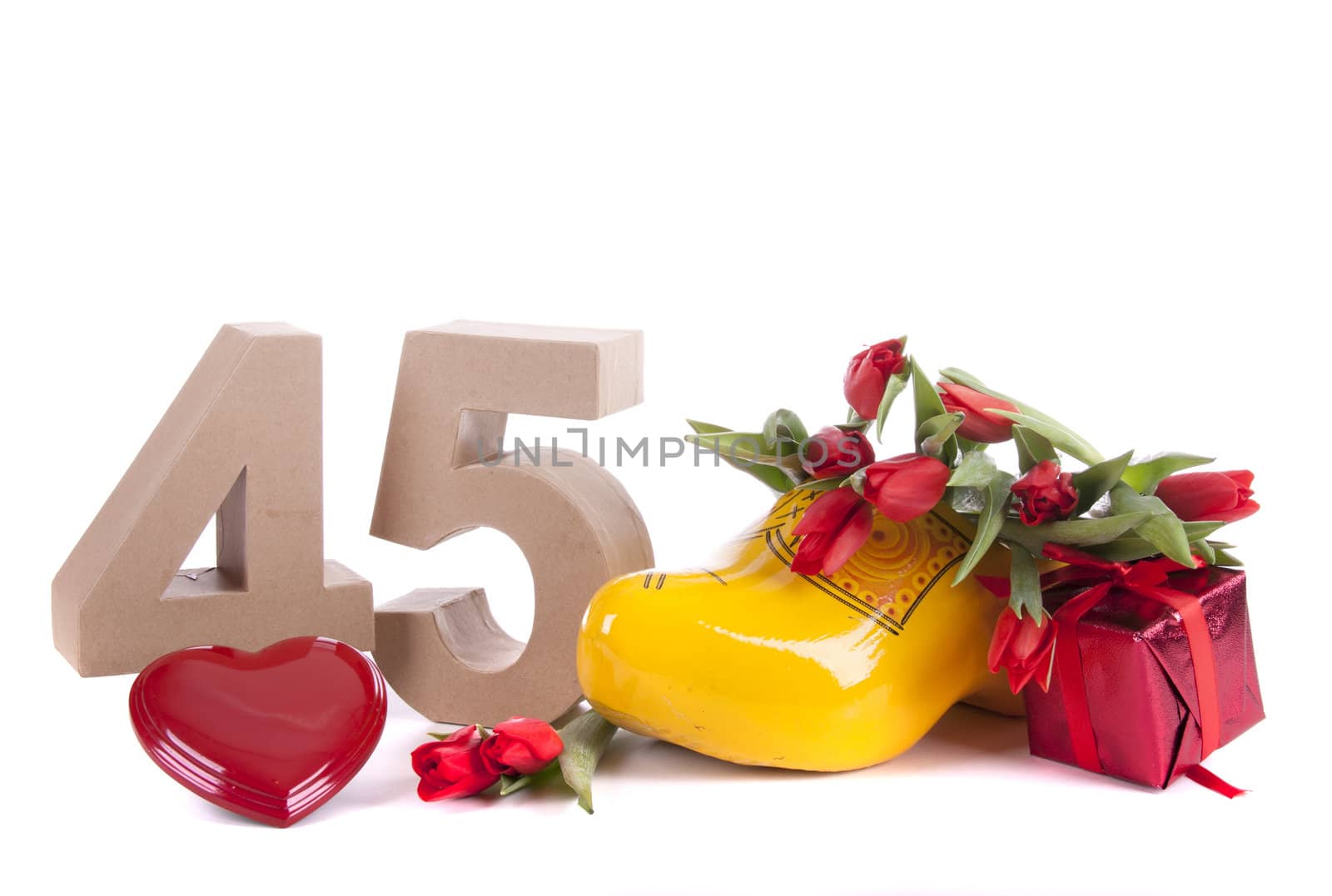 Number of age in a colorful studio setting and Dutch looking attributes like a clog woonden shoe and tulips