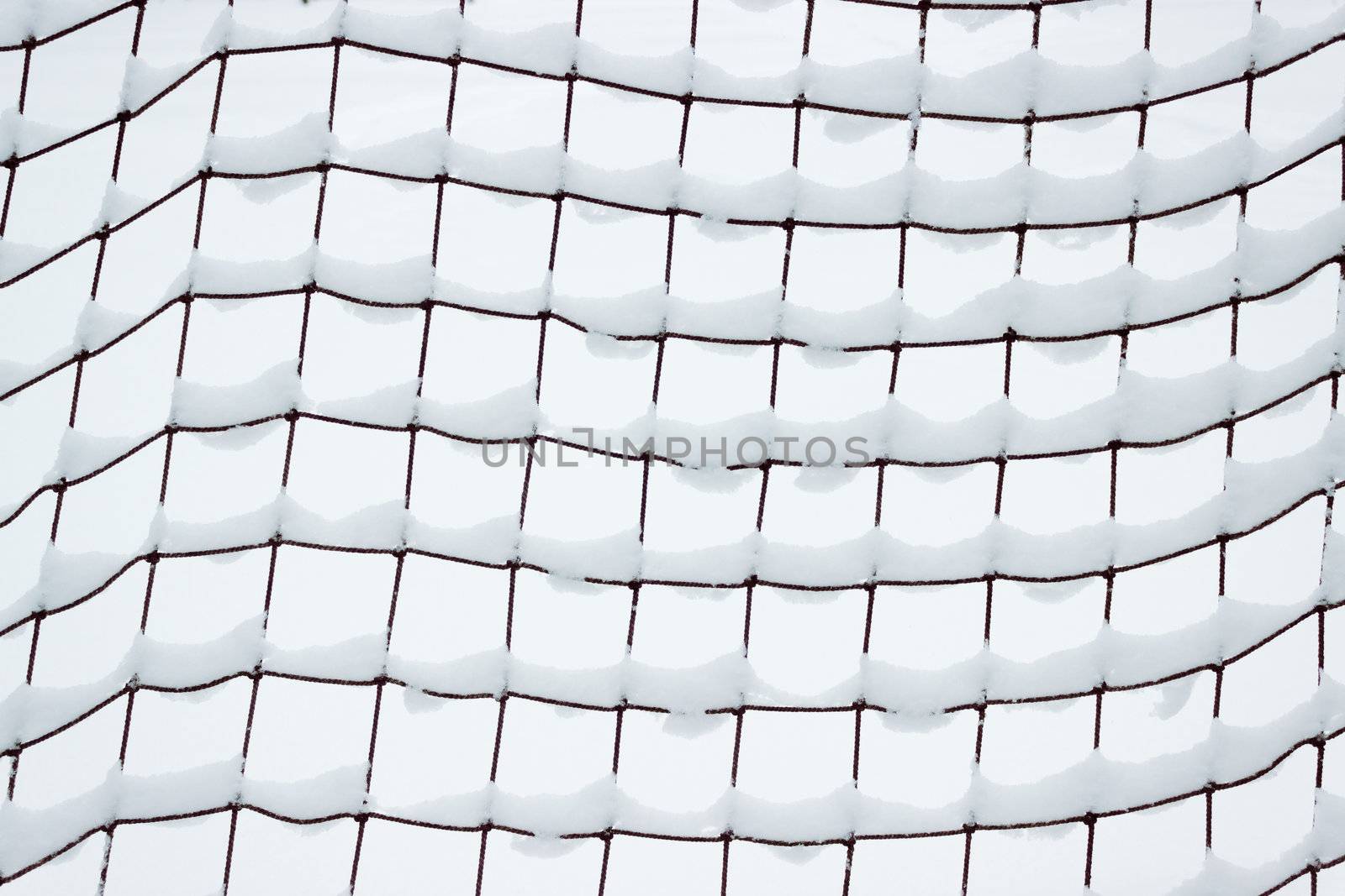 Football goal net, covered with snow in January