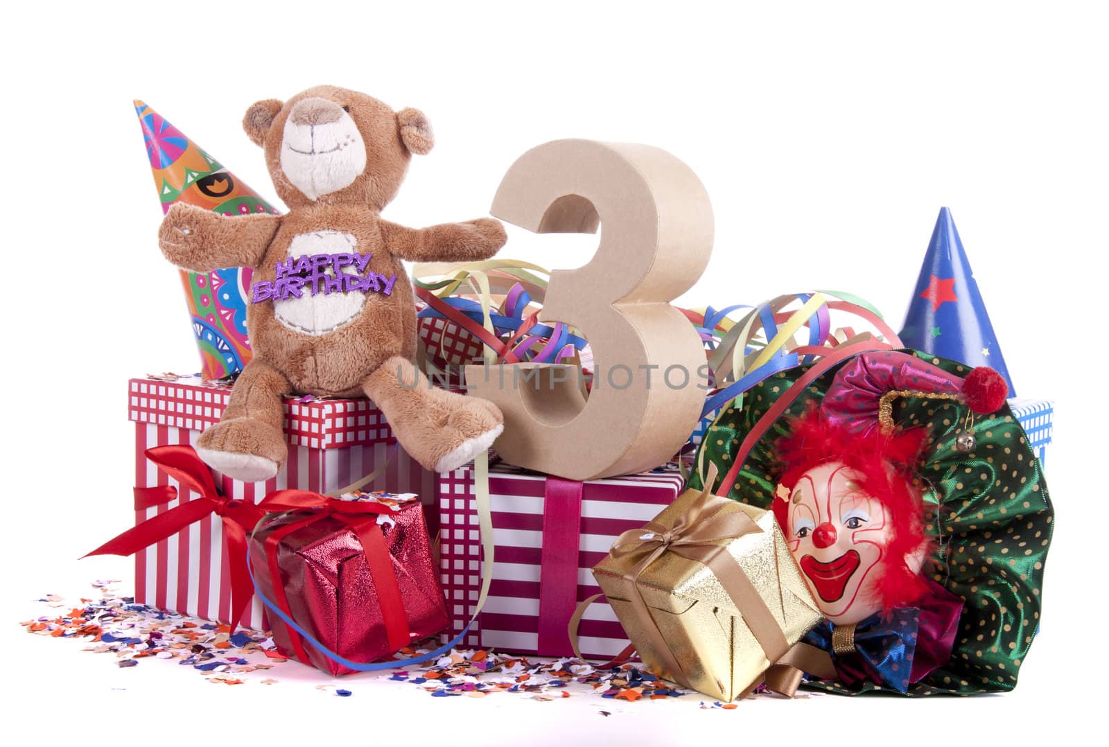 Number of age in a colorful studio setting with paper party hats, a red heart and gifts on a bottom of confetti for  childrens birthday party

