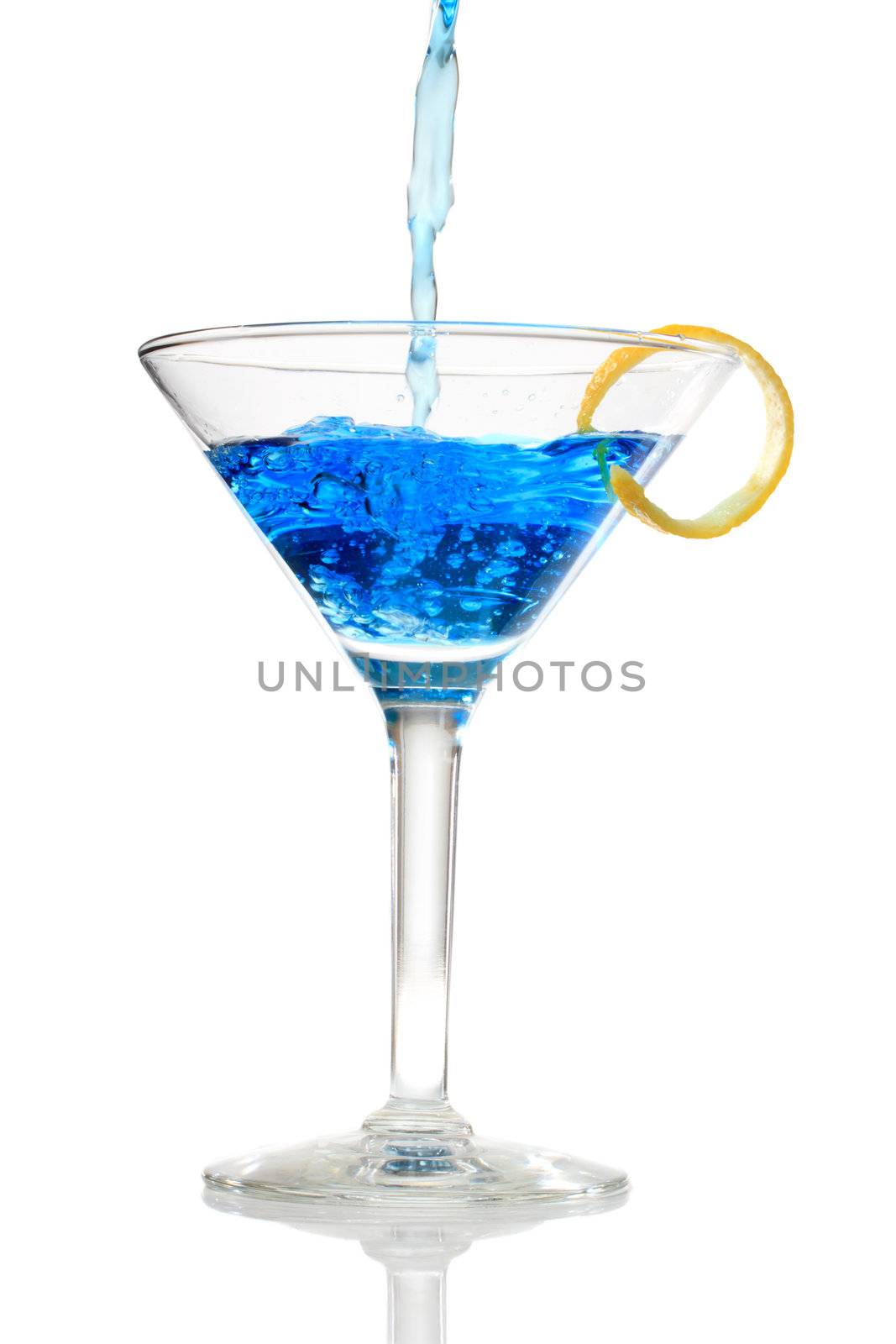  Blue cocktail being poured into a glass on white background