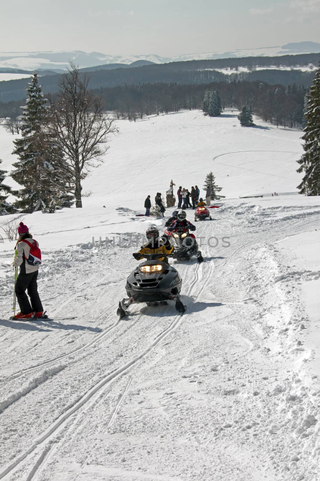 Some people riding on a snowmobile on a hillside