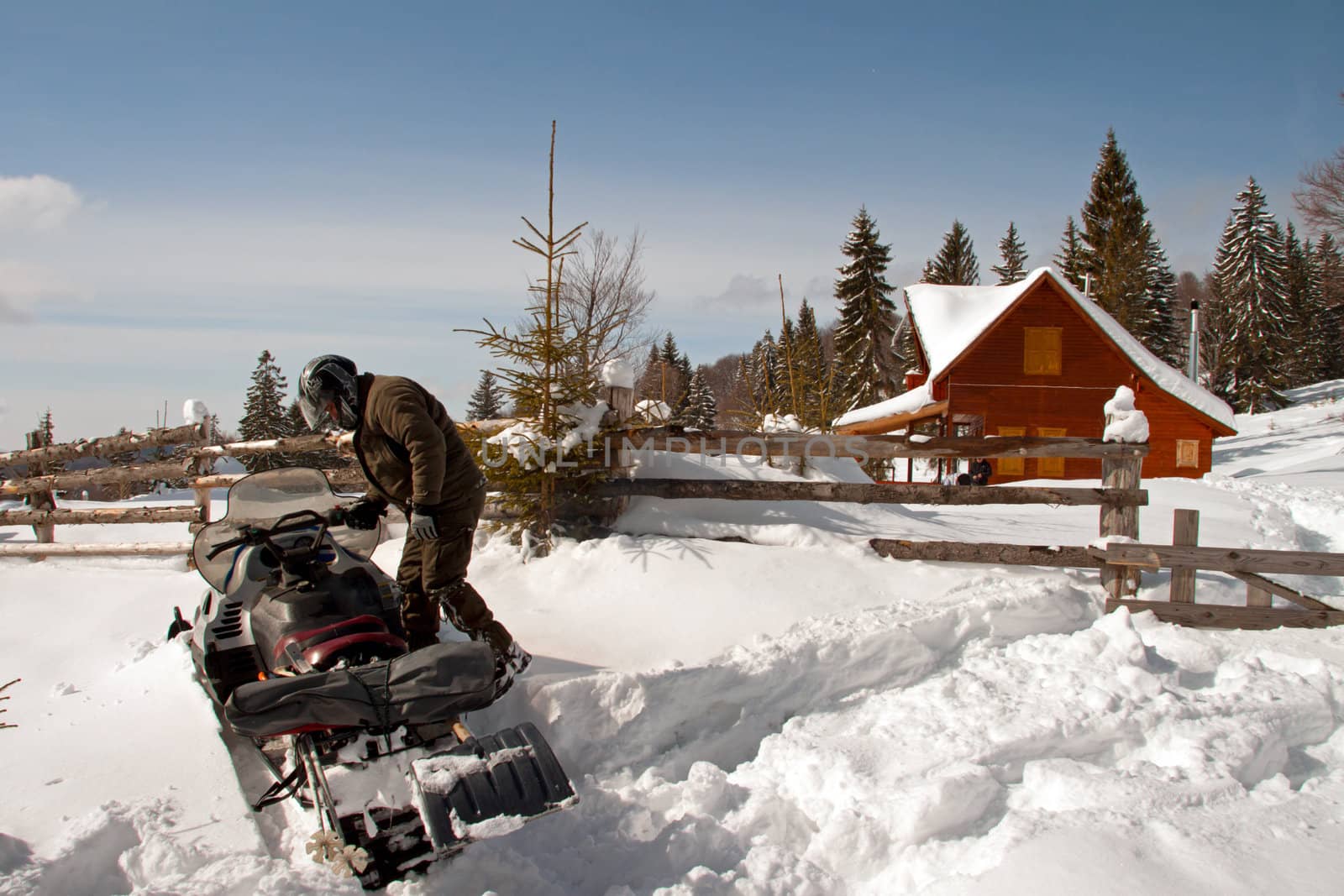 A man is preparing to ride on a snowmobile