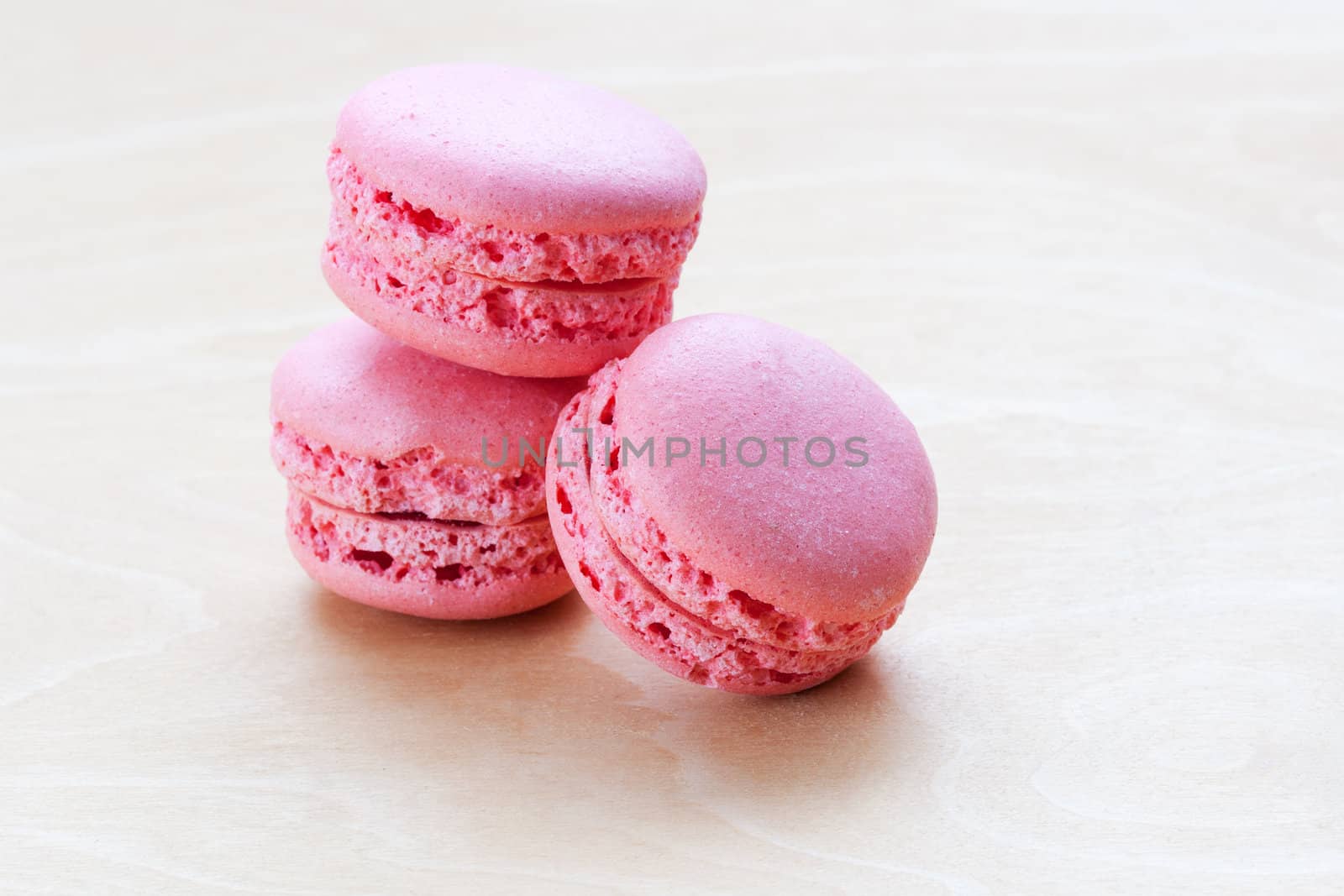 pink macaron on wooden background by sfinks