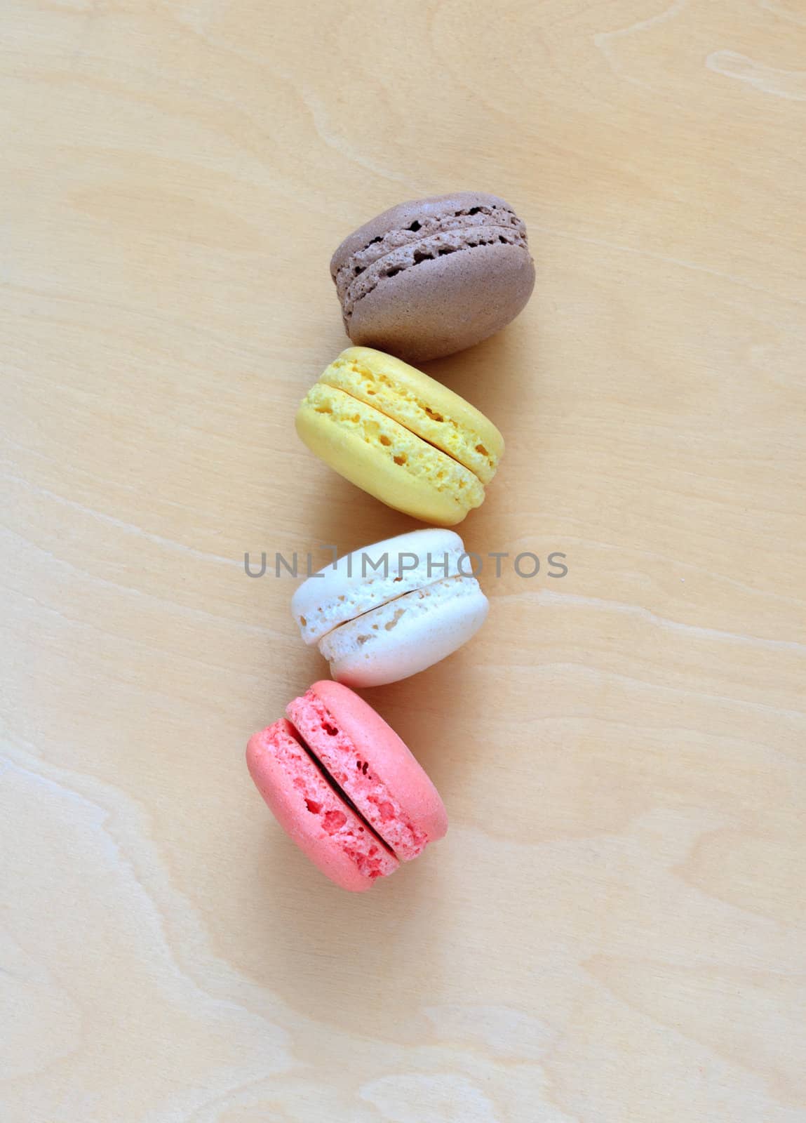 Colorful macaroons on wooden background by sfinks