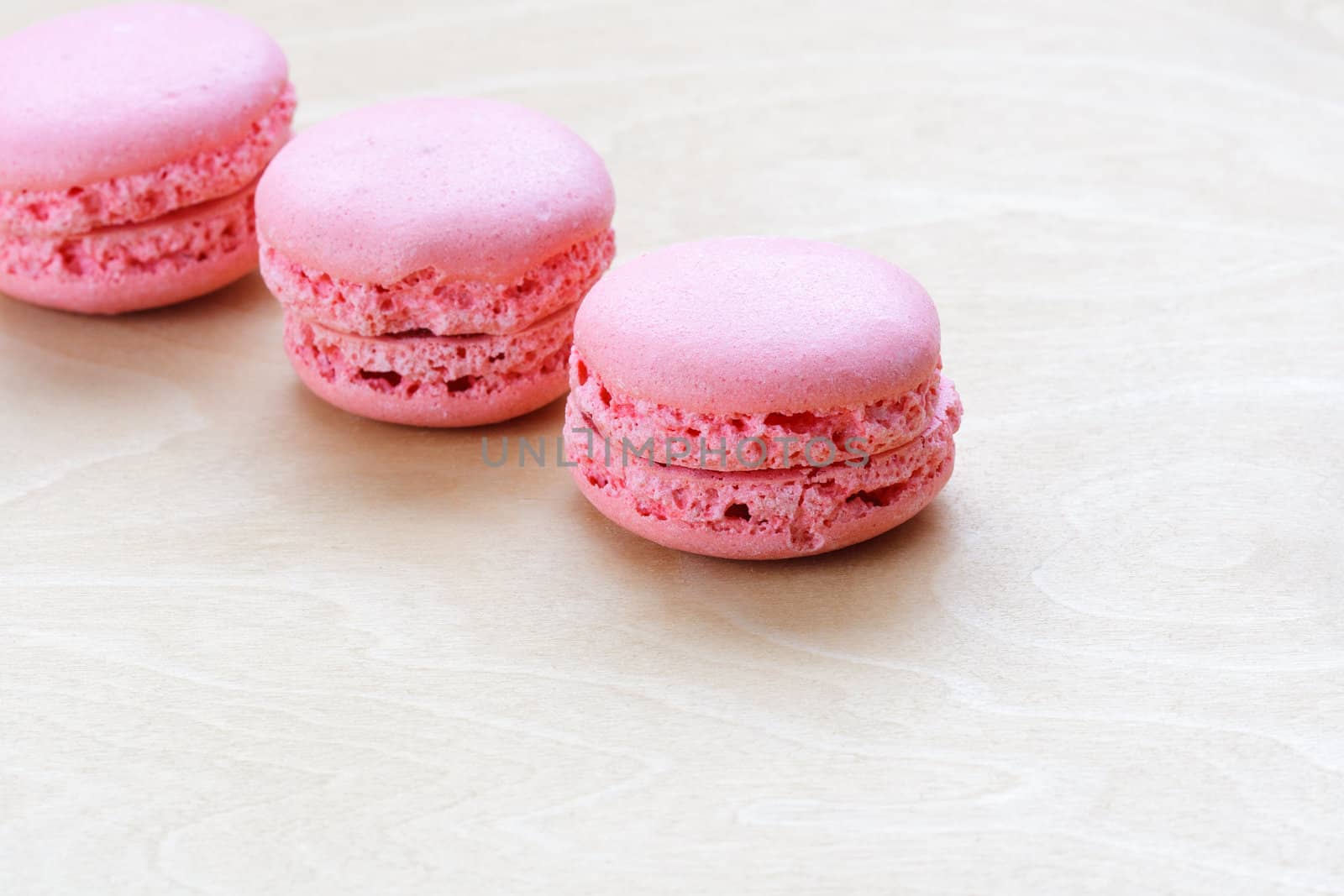 pink macaron on wooden background by sfinks