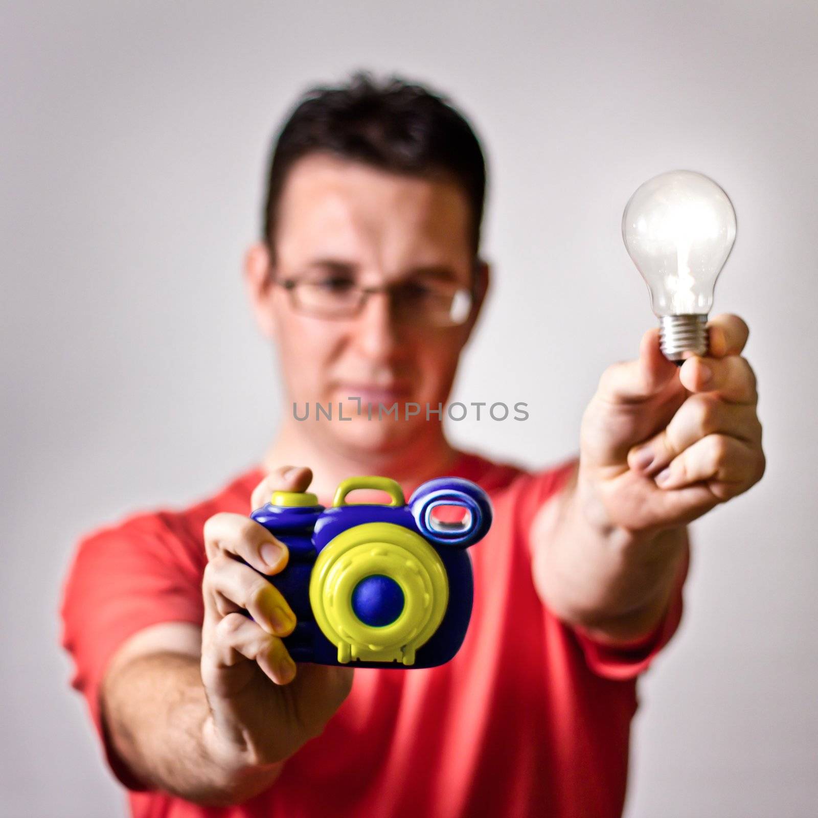 Front view of photographer holding colorful toy camera and handm by doble.d