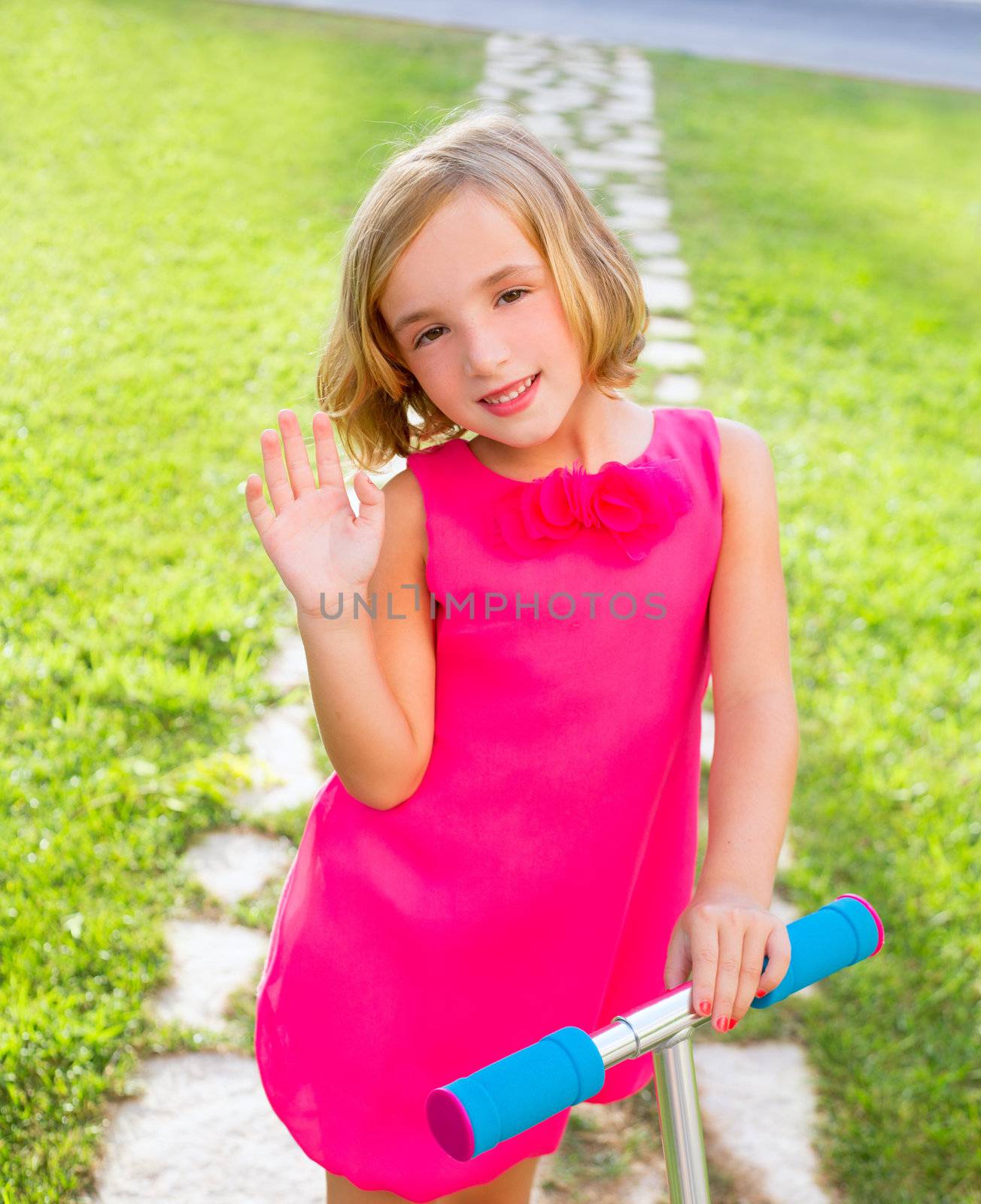 child happy girl playing with scooter in garden happy greeting hand gesture