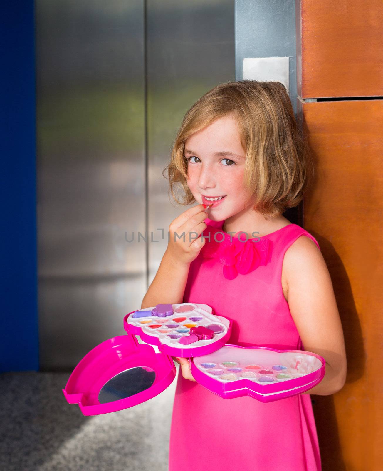 child kid girl playing with makeup lipstick in the lift door smiling happy