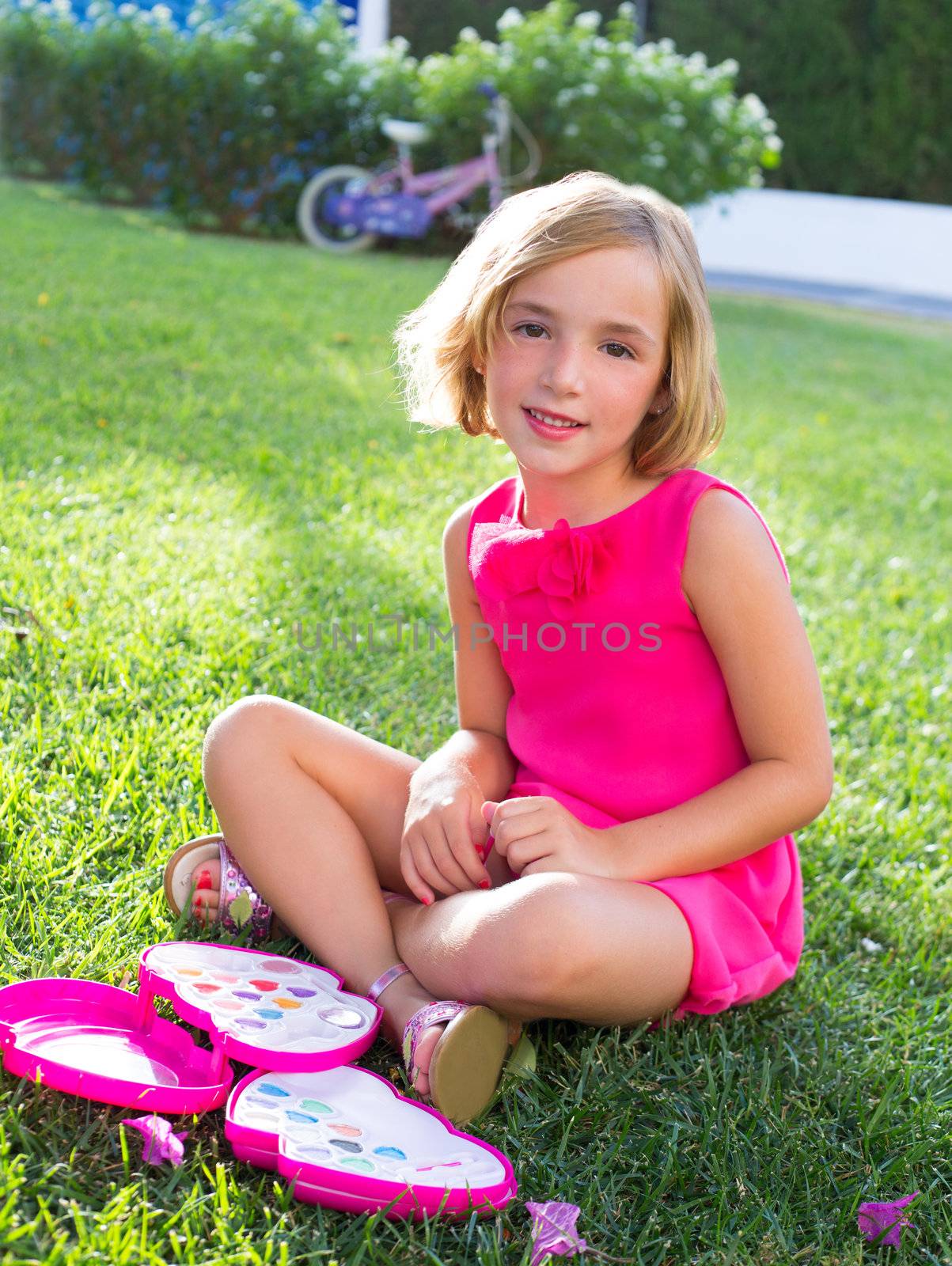 child kid girl playing with makeup set in sitting in garden grass smiling happy