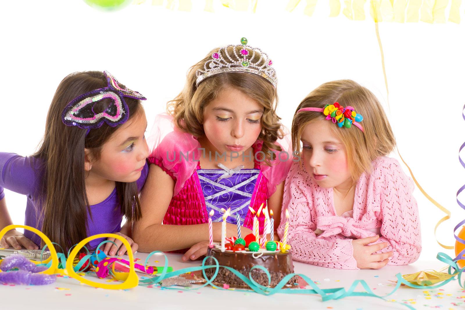 children happy girls blowing birthday party chocolate cake candles