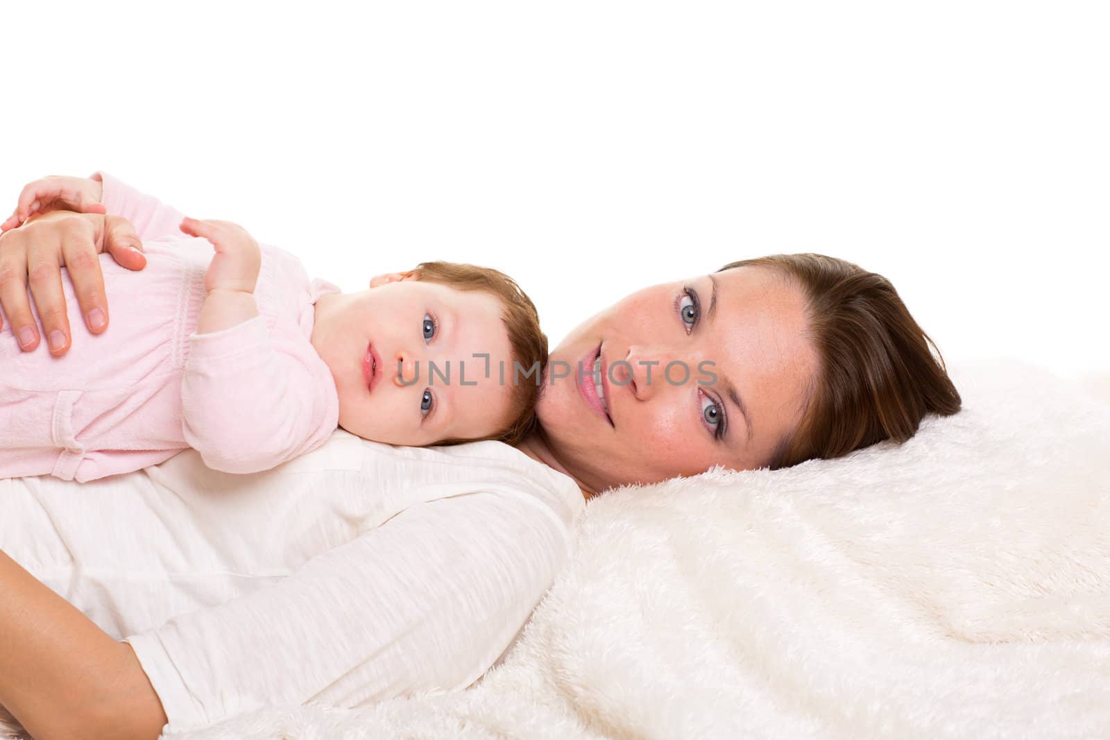 Baby girl and mother lying happy together on white fur by lunamarina