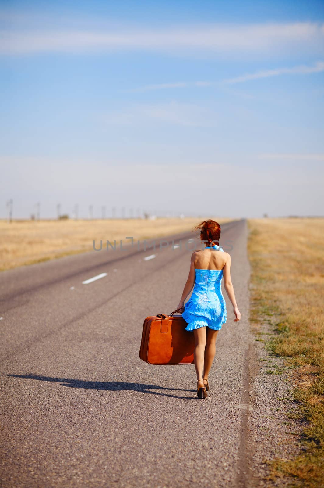 girl with luggage on the road by vsurkov