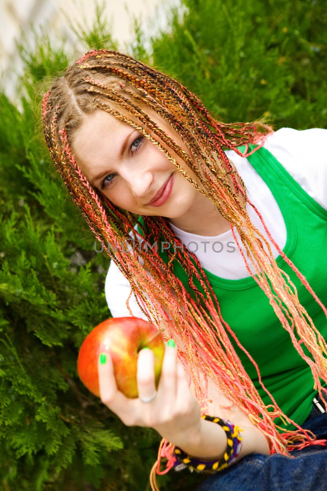 tennager girl with red apple on the green grass