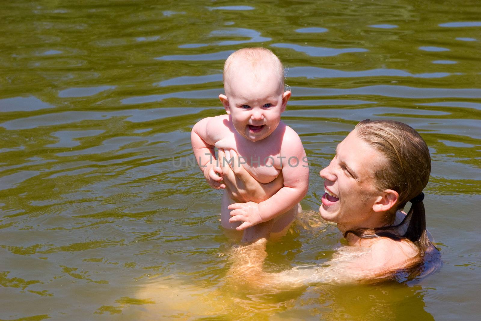one year old child swimming with dad