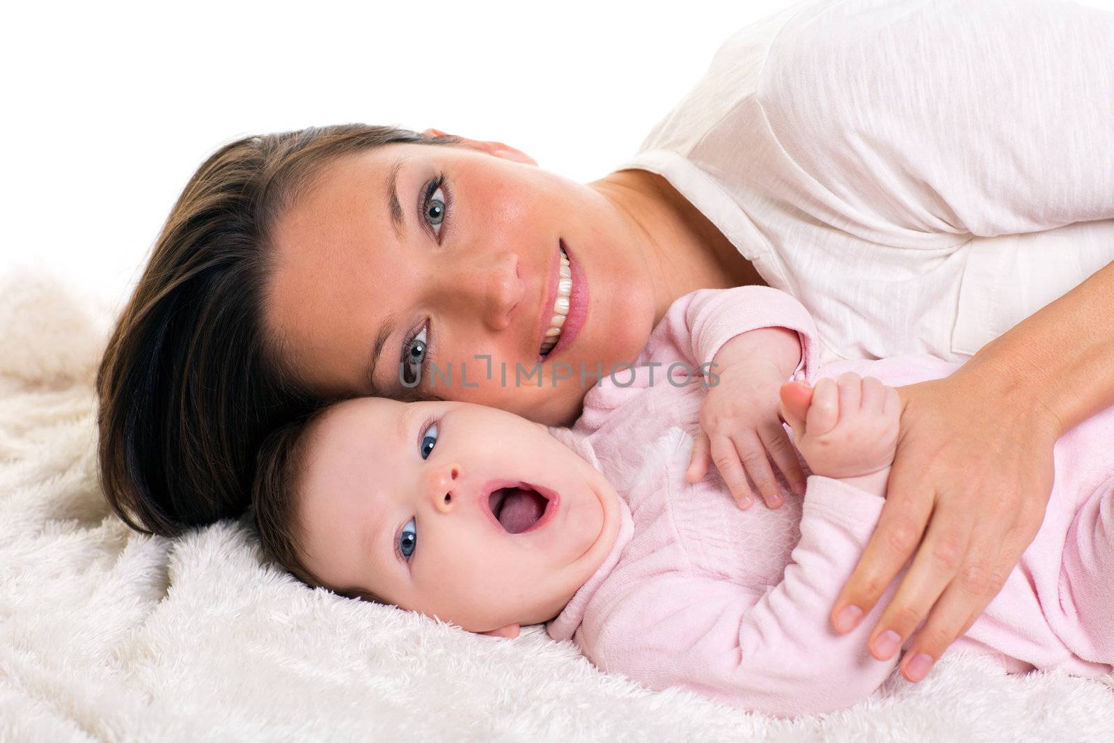 Baby girl yawning open mouth gesture with mother care near on white fur