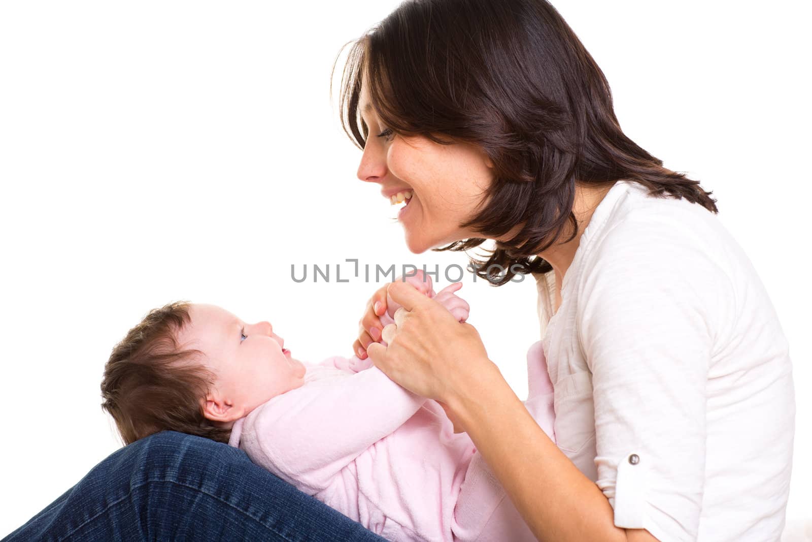 Baby girl on mother jeans knees playing together on white background