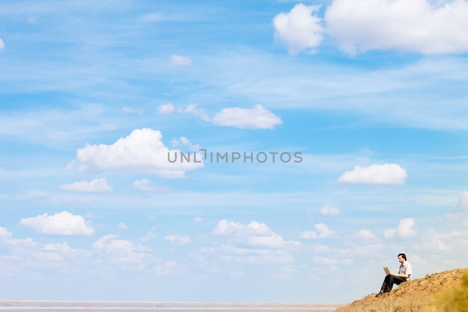 man with laptop and blue sky