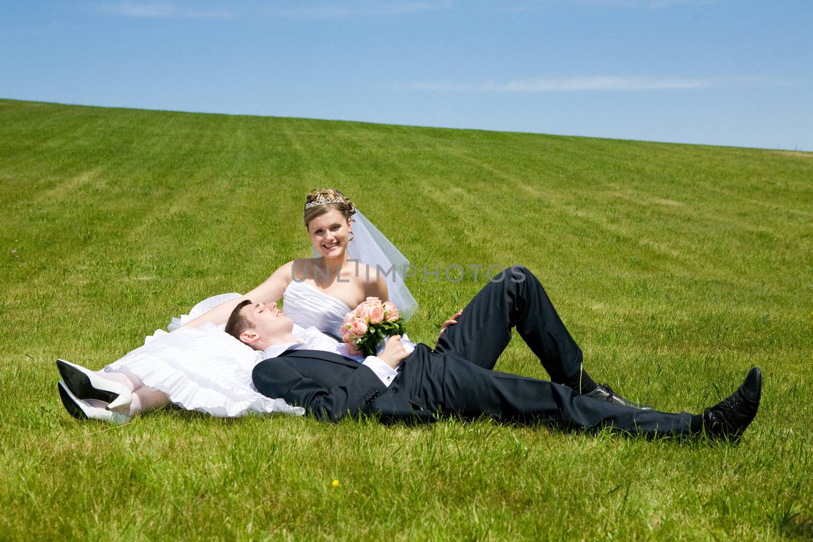 two happy people lay on the grass