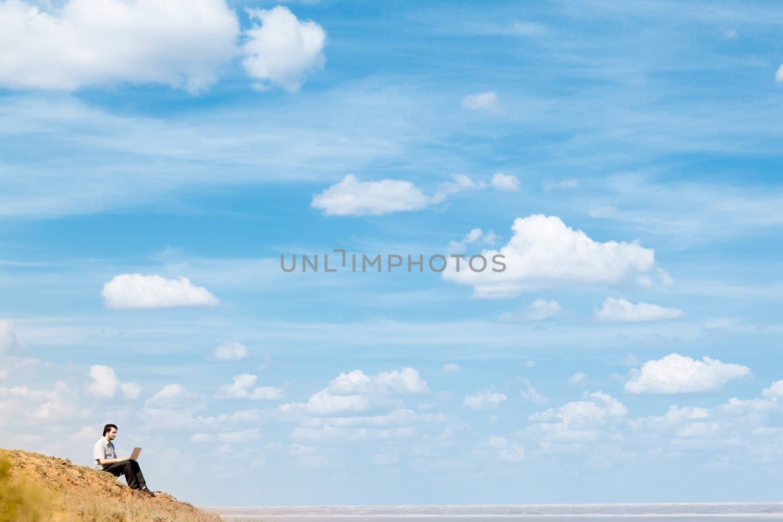 man with laptop and blue sky