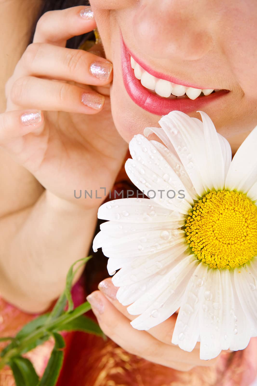 smiling lips of girl and camomile flower