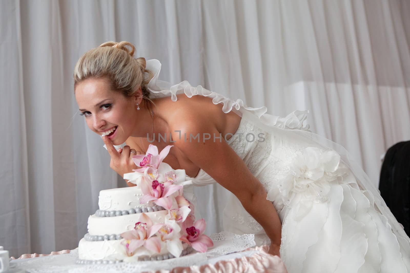 bride near a wedding cake with pink flowers