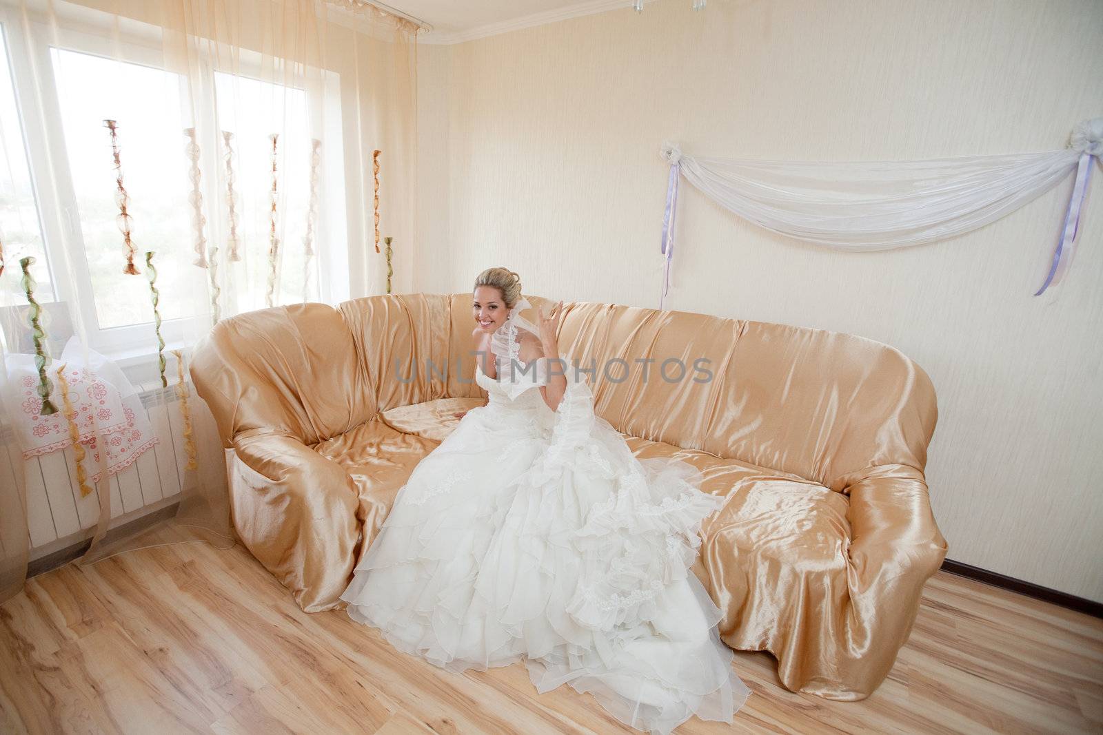 happy bride waiting for a groom on the sofa