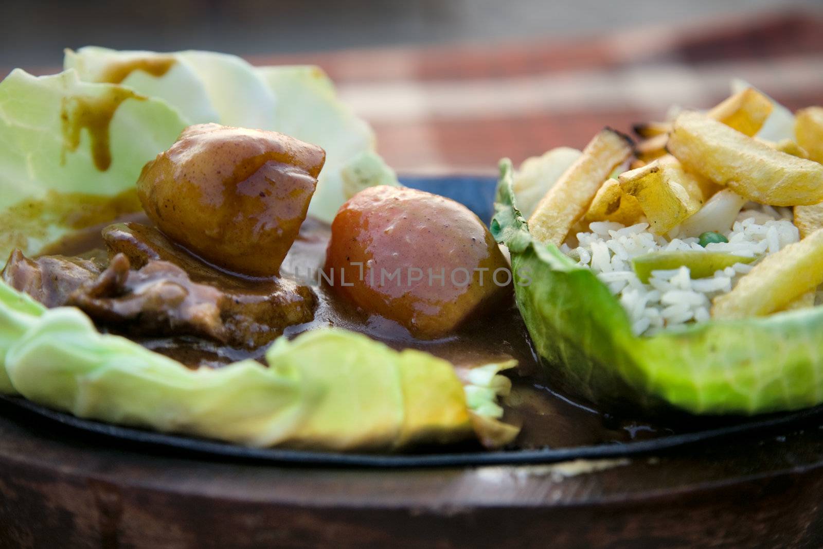 fried rise and potatoes with vegetables and fish on the  griddle