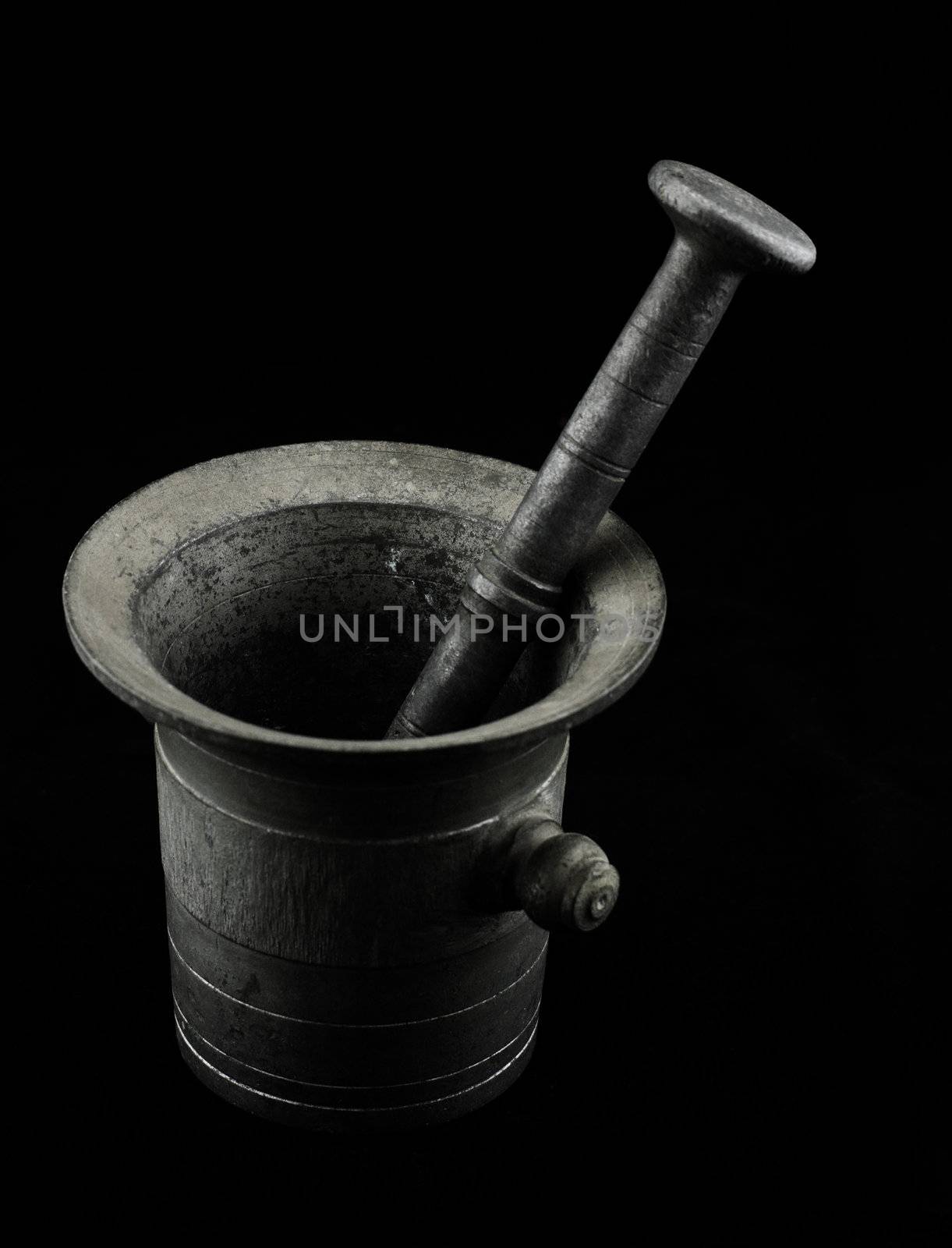 Old mortar with pestle on black backround