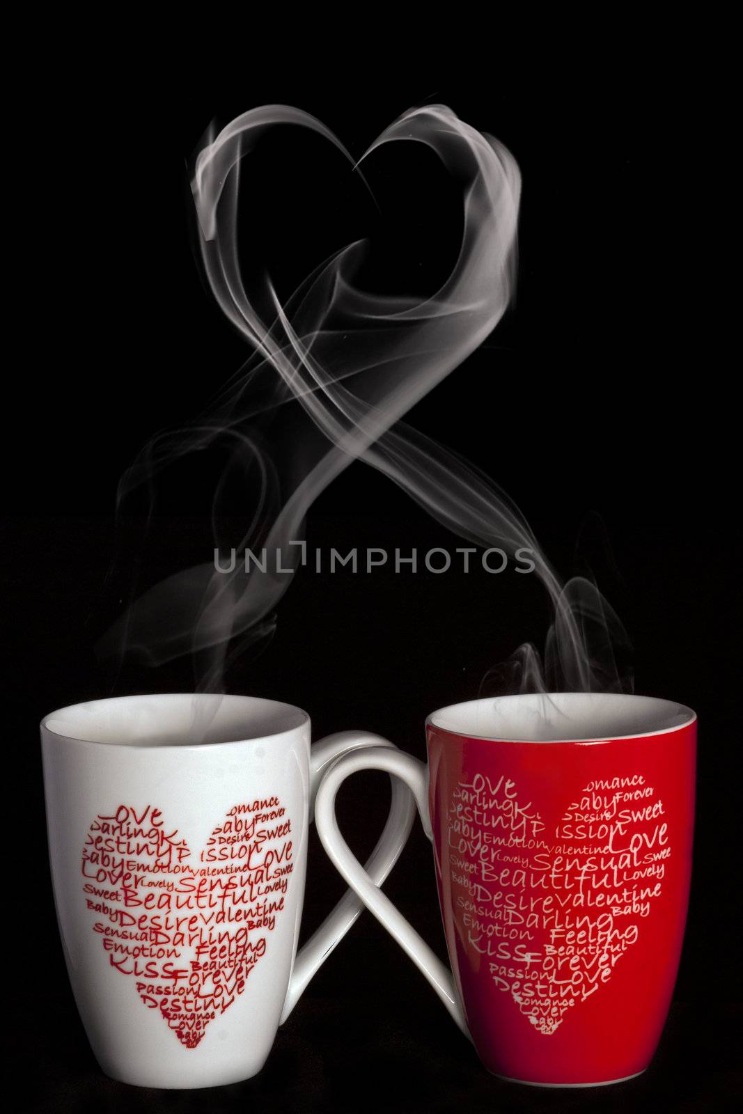 2 coffee cups with hearts creating smoke with shape of heart on a black background
