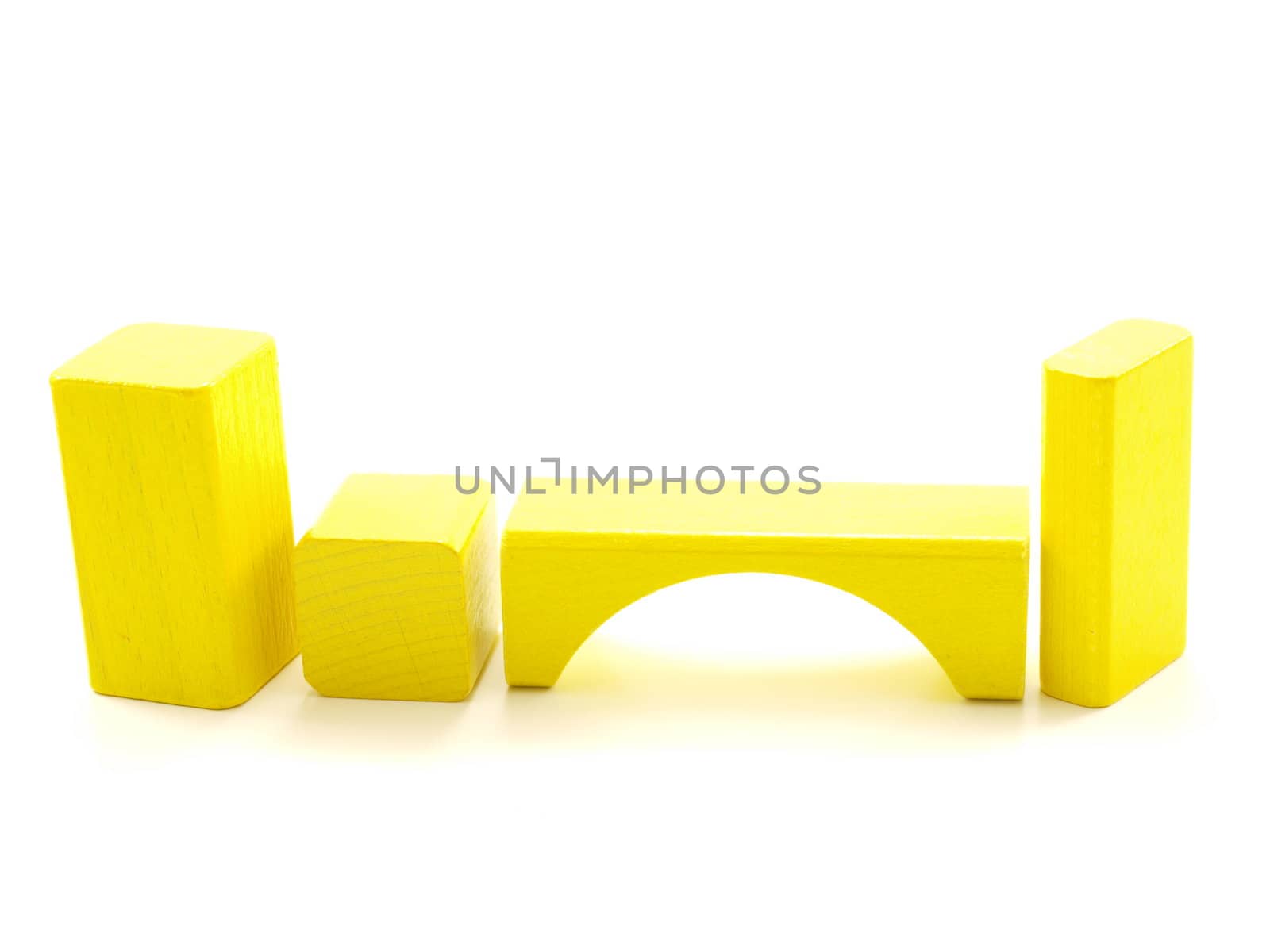 Wooden brick pieces of yellow color, isolated towards white