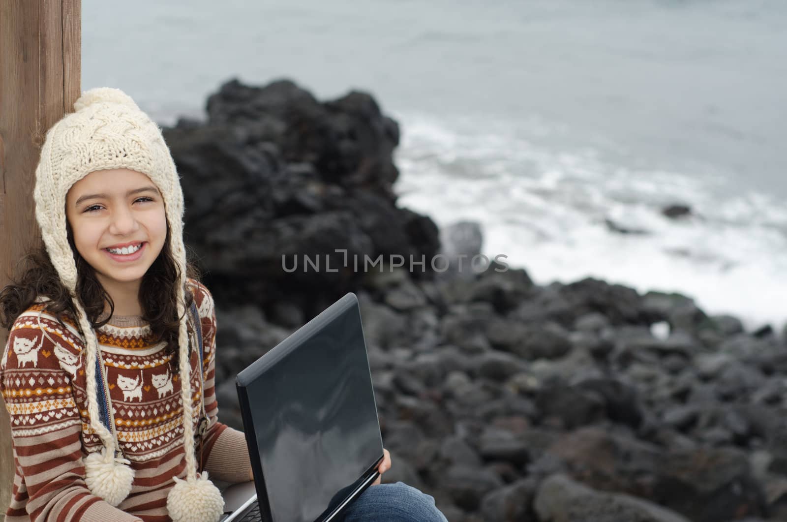 Cute child enjoying the outdoor with a laptop
